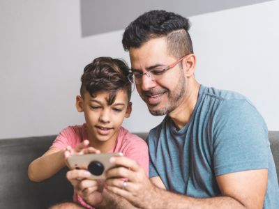 Mother shows her daughter a phone, using screens together can help with tantrums